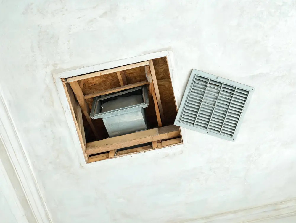 Ceiling supply register removed to show the duct boot above