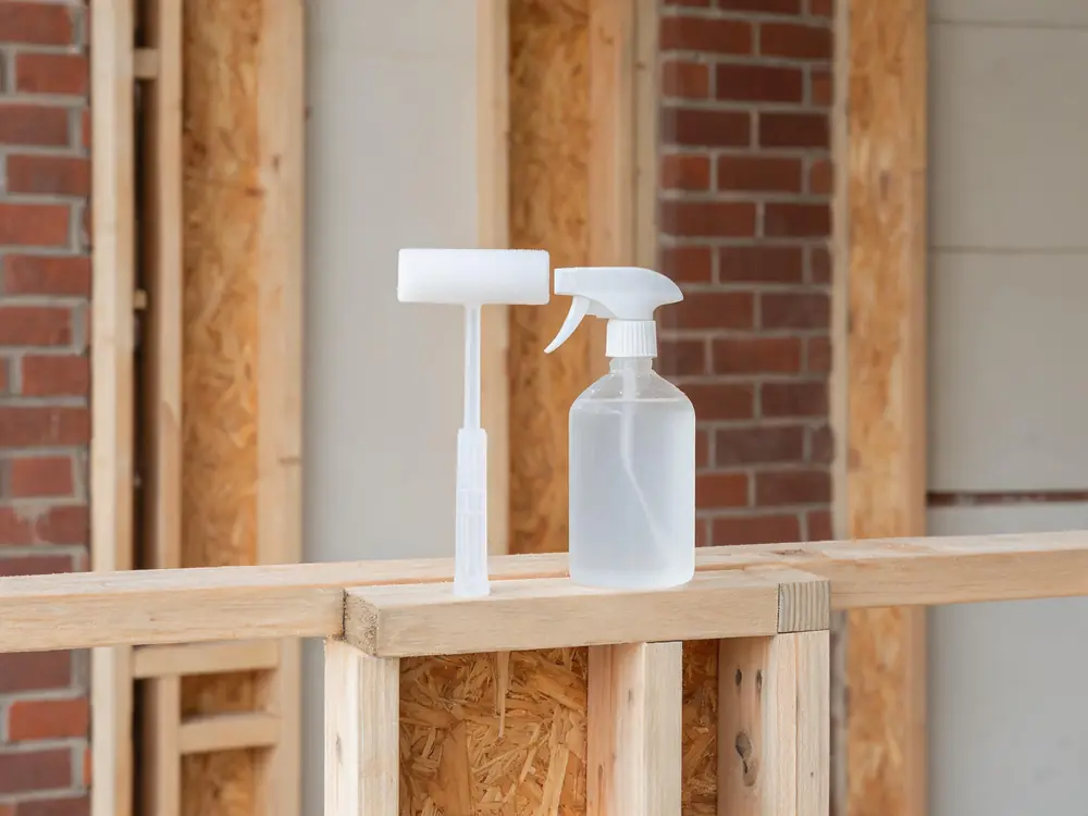 Pump sprayer resting beside cleaned framing
