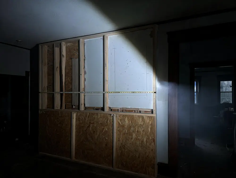 Tape measure pulled across a damaged wall section