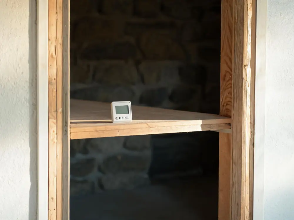 Digital hygrometer showing high humidity in a basement