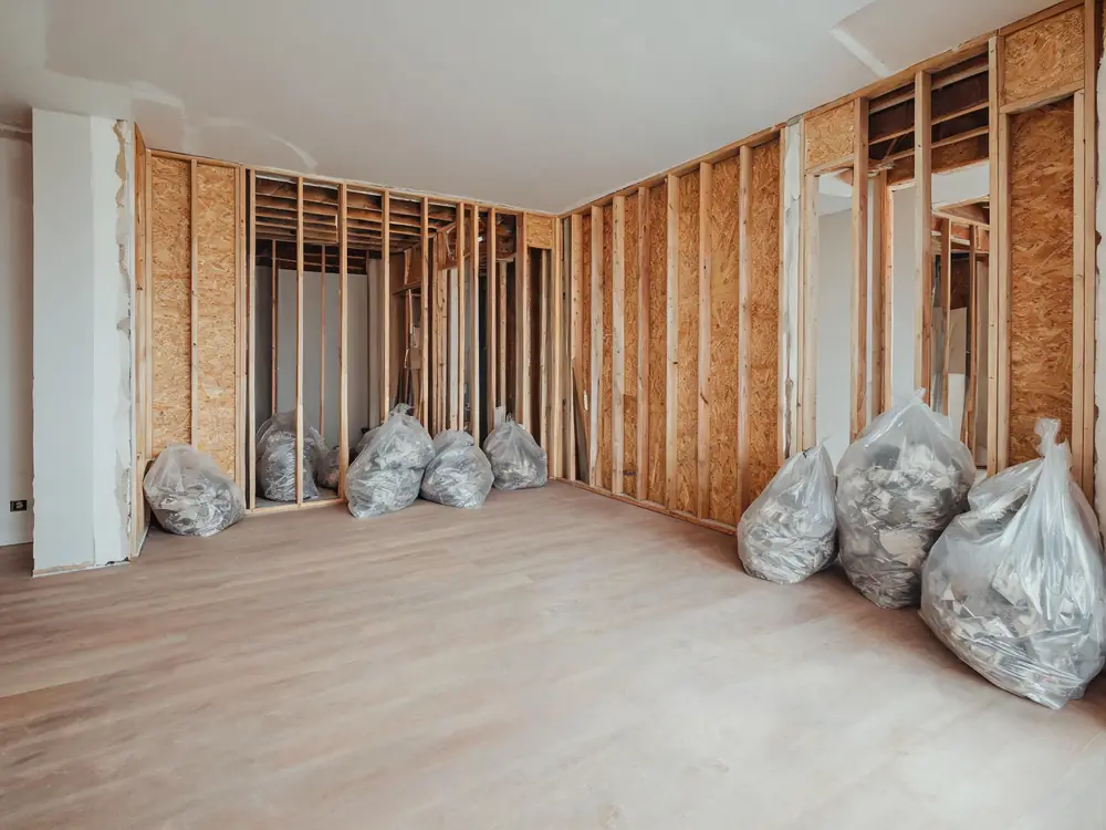 Room mid-remediation with contents bagged and framing exposed